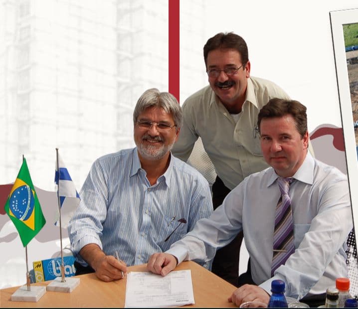 Assinatura de contrato entre a GNG e a Junttan, com as bandeiras do Brasil e da Finlândia